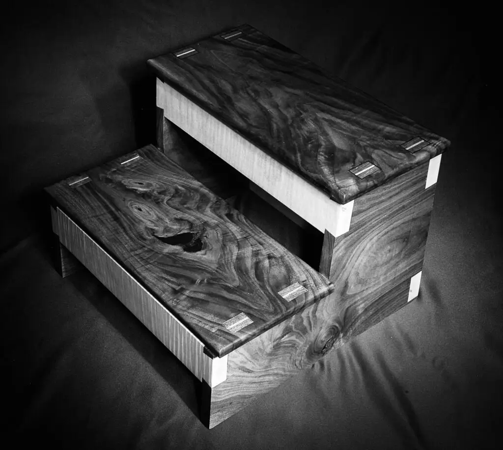 Black and white photograph of walnut and curly maple step stool