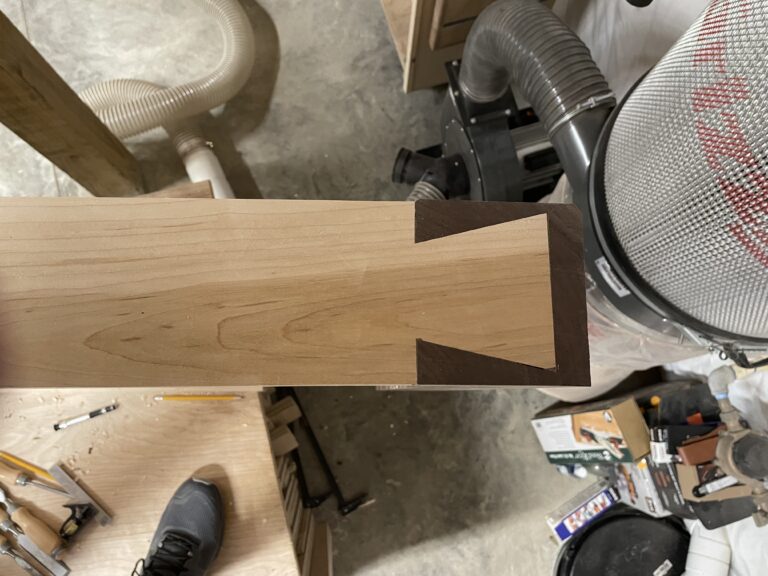 Close-up of a large single dovetail joint joining the end of a custom hardwood workbench.